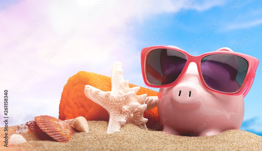 Piggy bank on sandy beach background