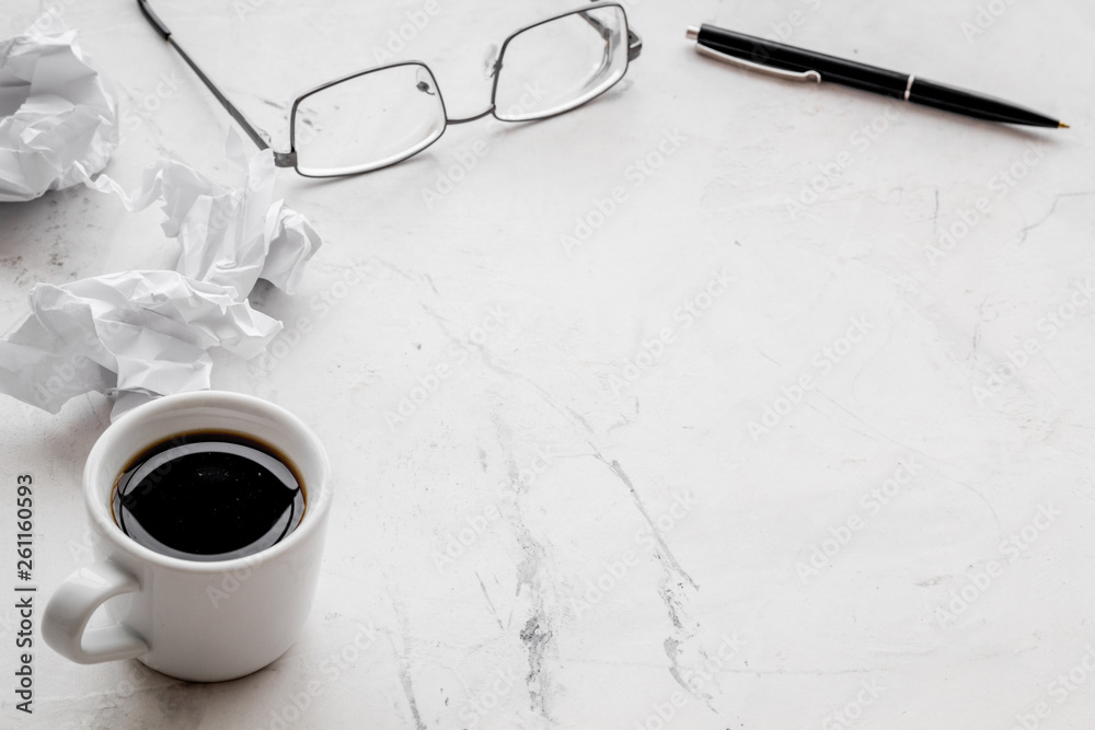 blogger office desk with glasses, coffee and paper balls on stone background copyspace blogger office desk with glasses, coffee and paper balls on stone background copyspace