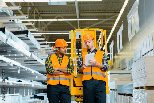 selective focus of concentrated workers using digital laptop in warehouse