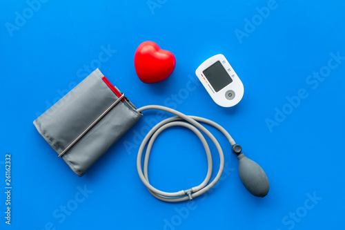 pulsimeter on the desk of the doctor for diagnostics of cardiac disease on blue background top view