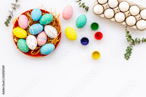 eggs with colorful paint for easter tradition on white background top view mockup