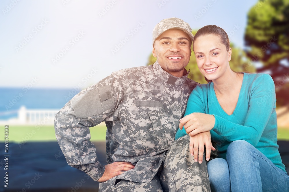 Smiling soldier with his wife standing against background Smiling soldier with his wife standing against background