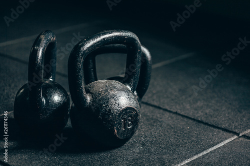 Fototapeta Naklejka Na Ścianę i Meble -  Black heavy kettlebells on gray floor, weightlifting