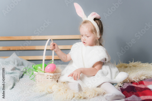 Little girl in a rabbit costume with a basket of Easter eggs