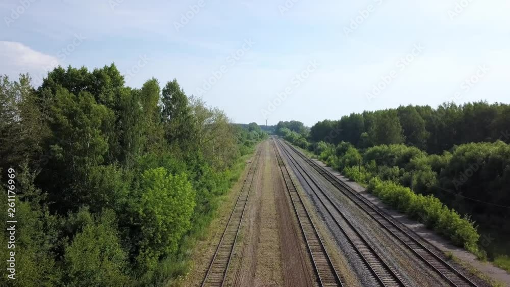 Summer scenery of empty long railways laying between green line of bushes and trees at some suburb area on warm summer sunny day in the countryside. Summer scenery of empty long railways laying between green line of bushes and trees at some suburb area on warm summer sunny day in the countryside.