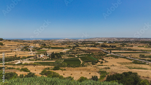 Fields and plain under blue sky viewed from the city of Mdina, Malta