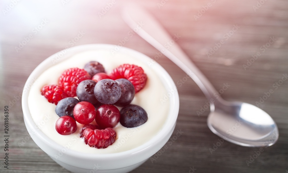 Yogurt with forest berries on wooden table Yogurt with forest berries on wooden table