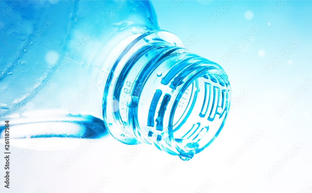 Water Drop Pouring out of Plastic Bottle on the Blue Background Water Drop Pouring out of Plastic Bottle on the Blue Background