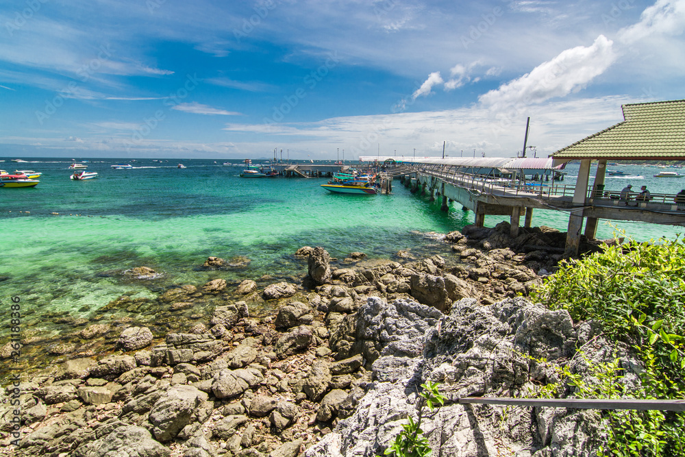 Obraz premium Wooden bridge walkway Rock the beach to the pier to transport tourists on the island on a clear day.