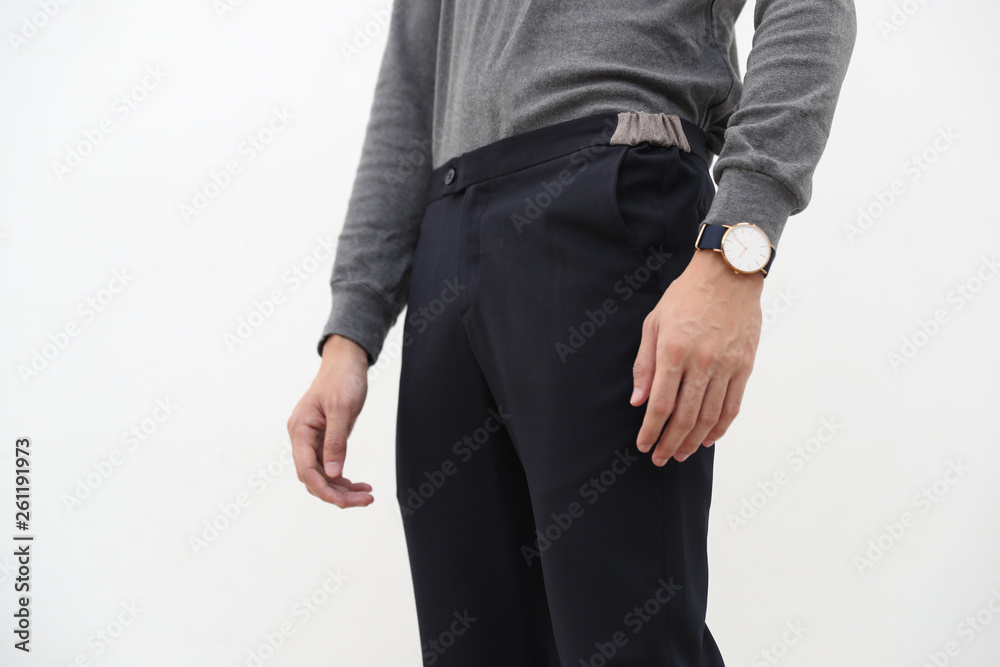 close-up of A handsome man in gray turtleneck shirt and black long trousers on white background.