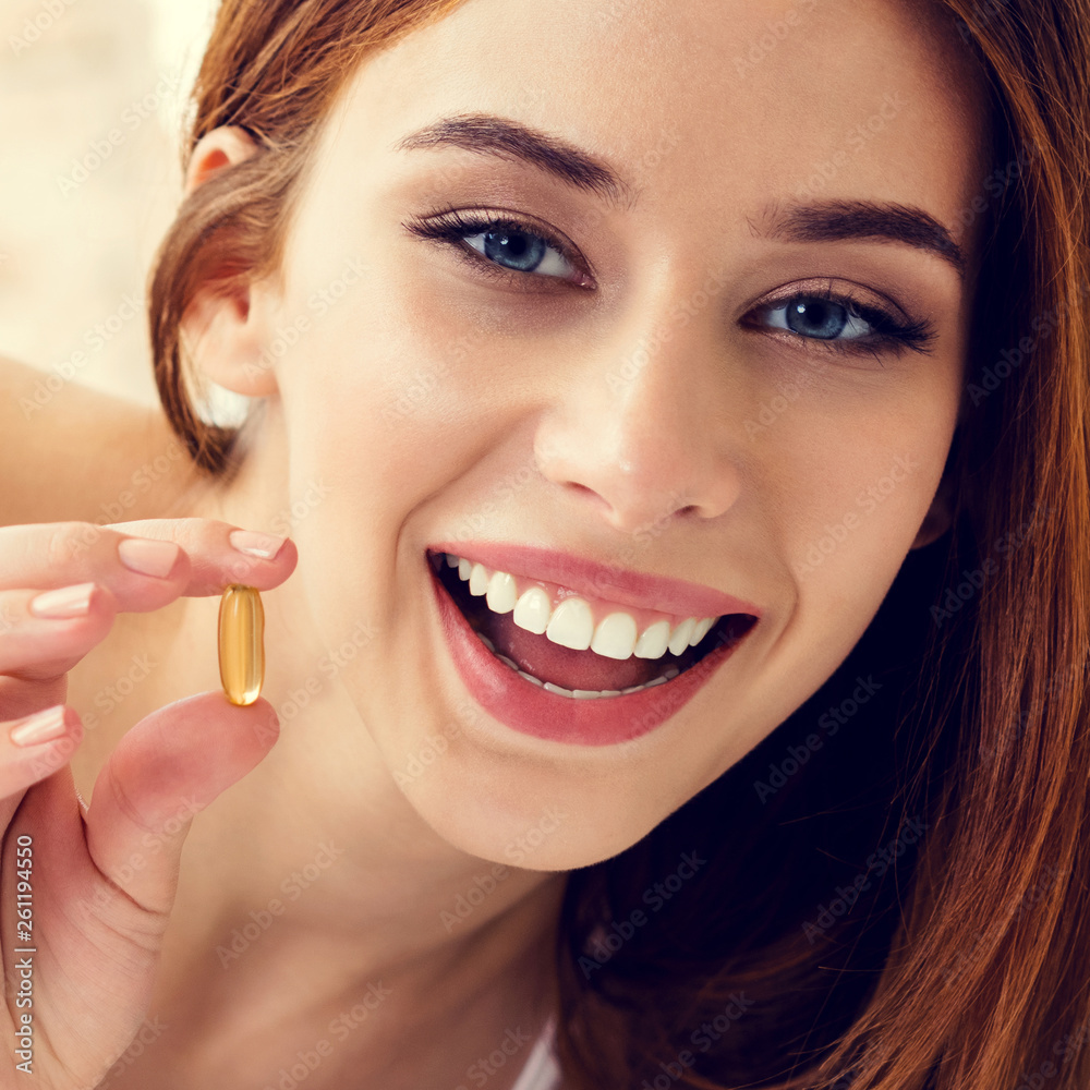 Woman with Omega 3 fish oil capsule, at home Woman with Omega 3 fish oil capsule, at home