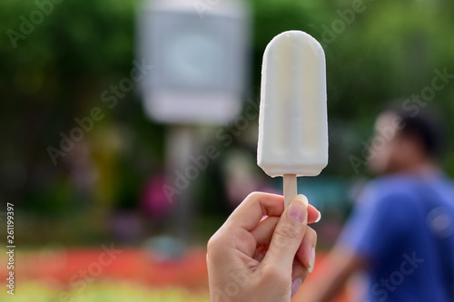 woman holding coconut ice cream in the park, ..delicious so should feel fresh in summer, summer light nature background.