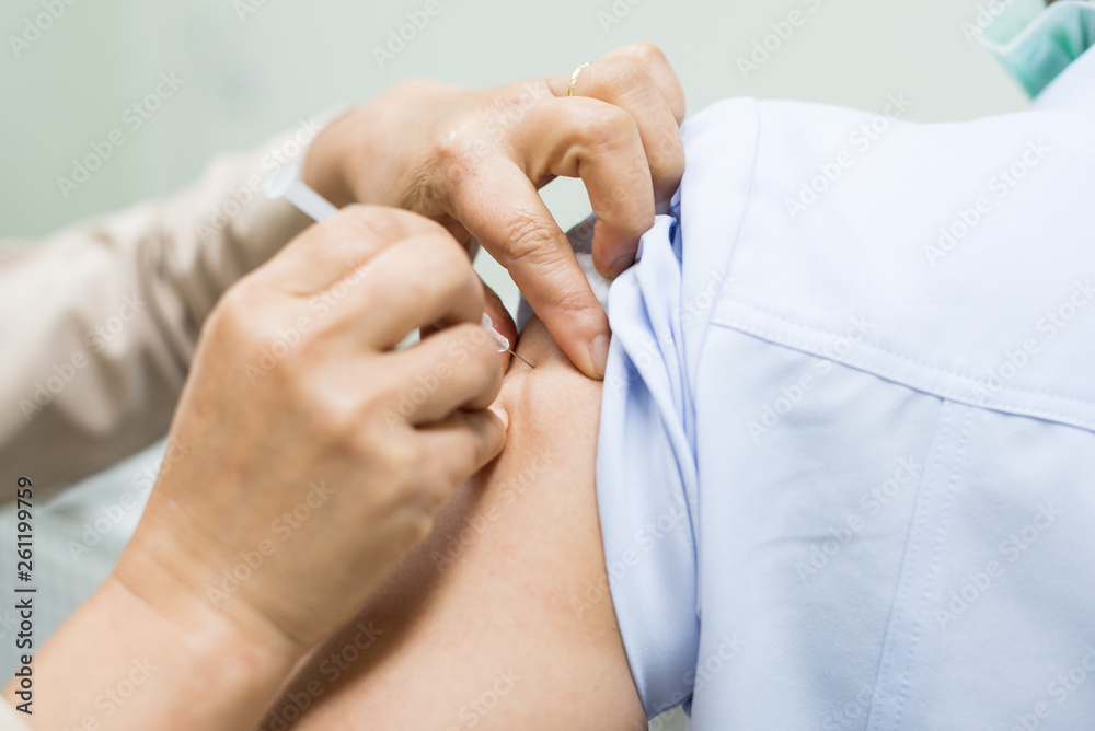 Close up doctor's hand injecting for vaccination in the shoulder woman patient.Vaccine for protection concept