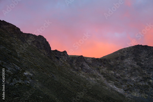 Picturesque sunset above the mountains ridge in Akchan valley. Altai Mountains. Russia