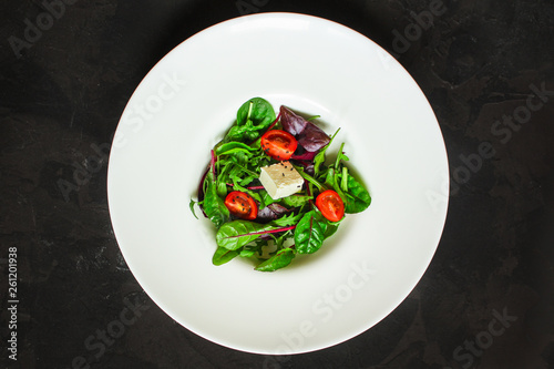 Healthy salad, leaves salad mix in a white plate and cheese (green, juicy snack). food background - Image