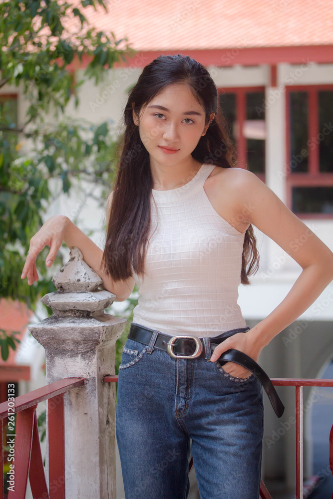 Portrait of thai china adult beautiful girl White shirt blue jeans relax and smile