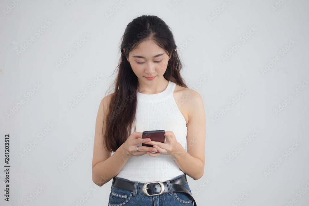 Portrait of thai china adult beautiful girl White shirt blue jeans using her smart phone Portrait of thai china adult beautiful girl White shirt blue jeans using her smart phone