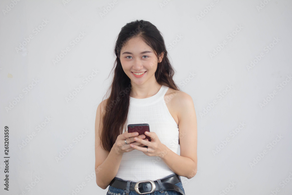 Portrait of thai china adult beautiful girl White shirt blue jeans using her smart phone Portrait of thai china adult beautiful girl White shirt blue jeans using her smart phone