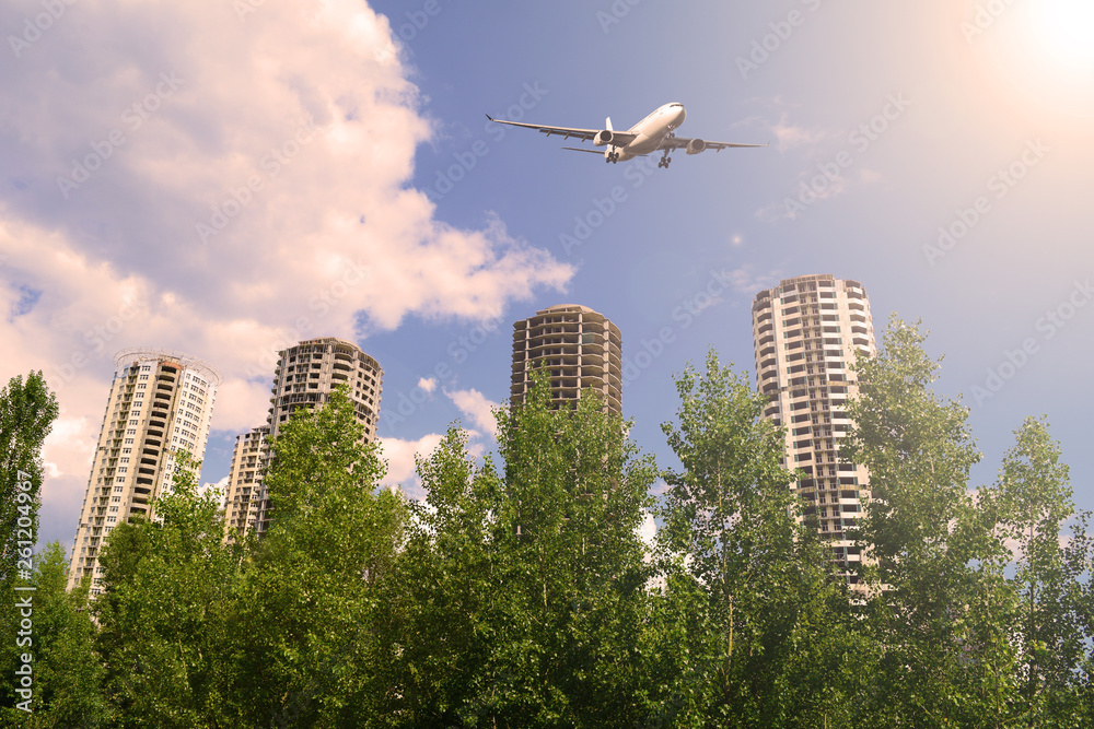 The plane in the sky over high-rise buildings in the city. Sunset. The plane in the sky over high-rise buildings in the city. Sunset.