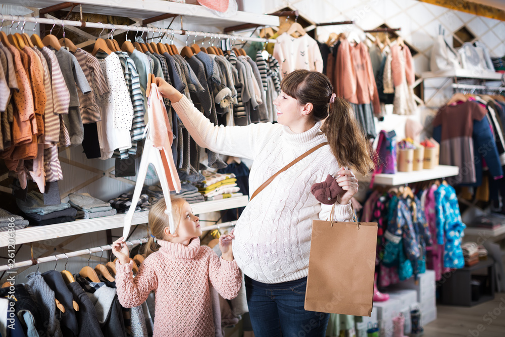 Fototapeta premium Pregnant woman examining baby's clothes