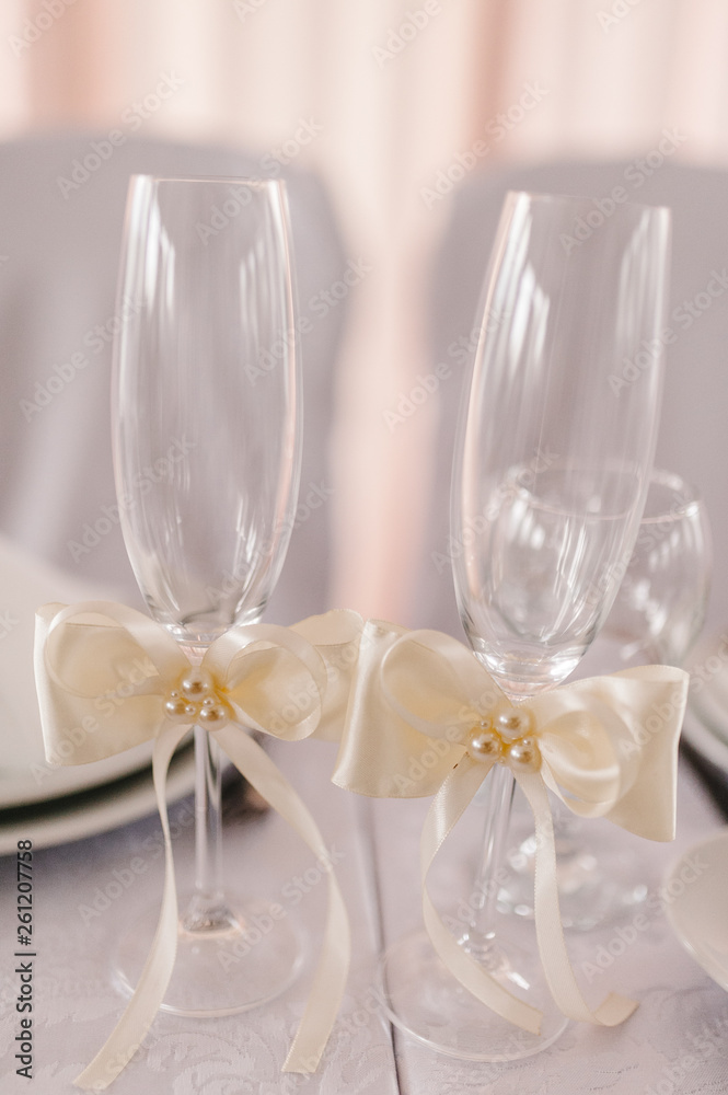Two Wedding glasses are decorated with ribbons. New Year, Valentine's Day. Close up. Two Wedding glasses are decorated with ribbons. New Year, Valentine's Day. Close up.