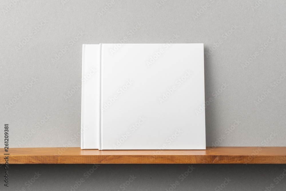 2 white square notebook on bookshelf and grey wall 2 white square notebook on bookshelf and grey wall