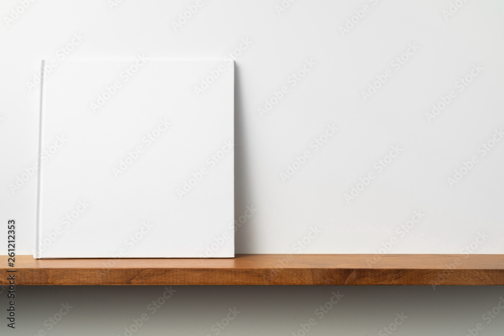 white square notebook on bookshelf and white wall white square notebook on bookshelf and white wall