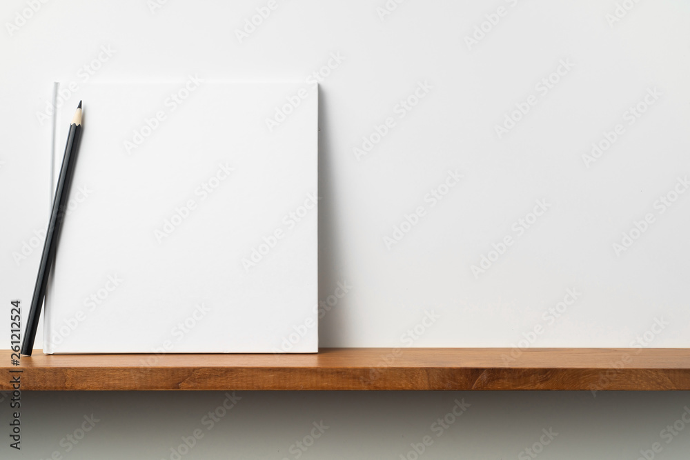 white square notebook on bookshelf and white wall white square notebook on bookshelf and white wall