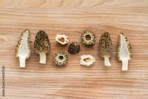 Slices of morel mushrooms on wooden cutting board photo