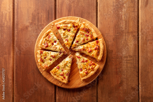A quiche, shot from the top on a dark rustic wooden background with a place for text