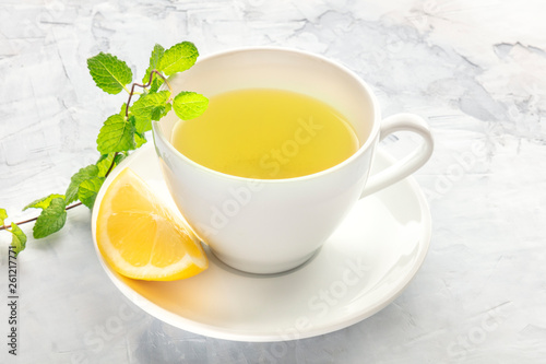 A photo of a cup of tea with lemon and mint with copy space
