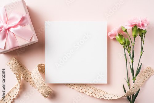 Fototapeta Naklejka Na Ścianę i Meble -  top view of carnation with card on pink background