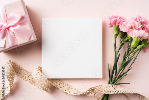 top view of carnation with card on pink background
