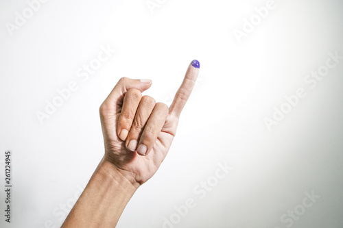 Inked blue finger of a man hand isolated on white background. blue ink blots from voters finger presidential election (pilpres) of indonesia. photo