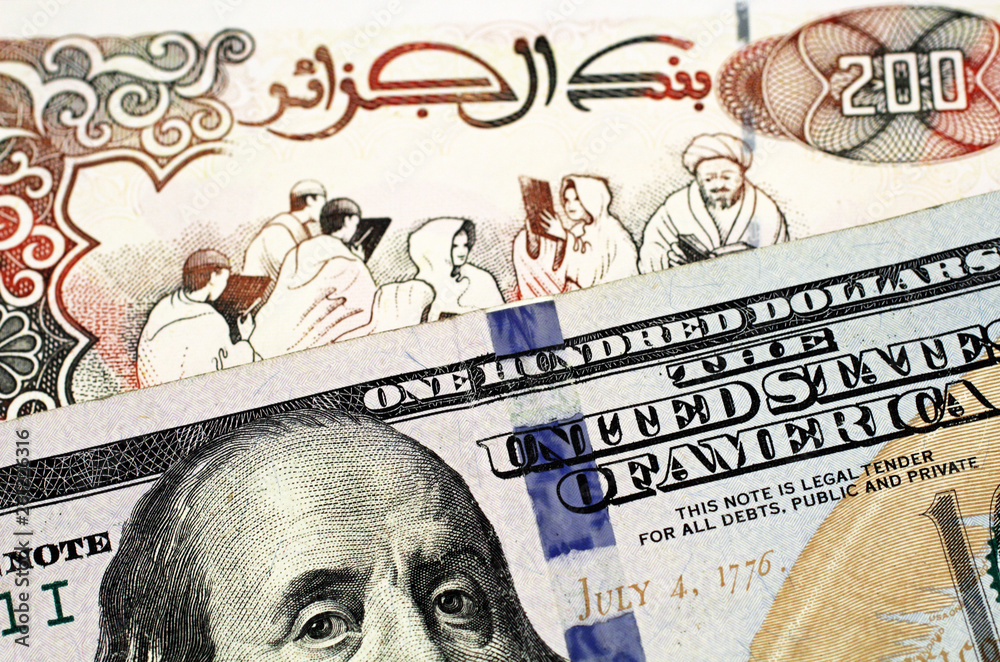 A close up image of an American one hundred dollar bill with an Algerian two hundred dinar bank note in macro