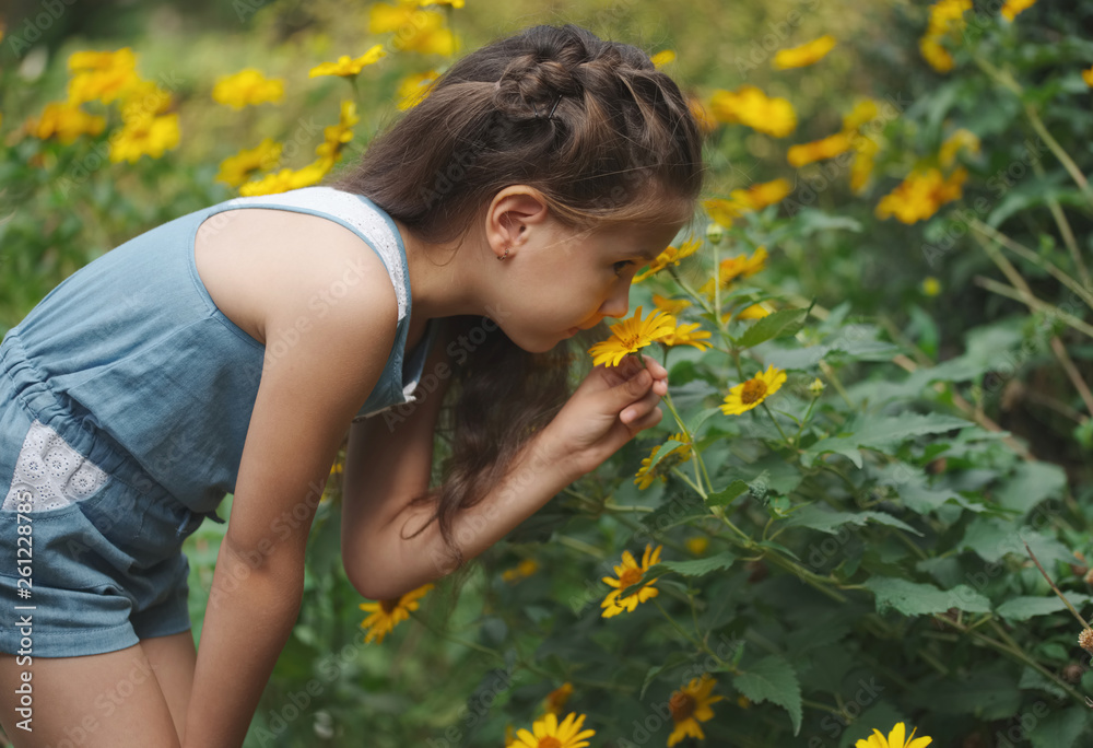 Fototapeta premium portrait of happy beautiful girl in flowerbed