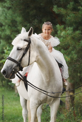 happy little princess on white horse in the forest © Aliaksei Lasevich