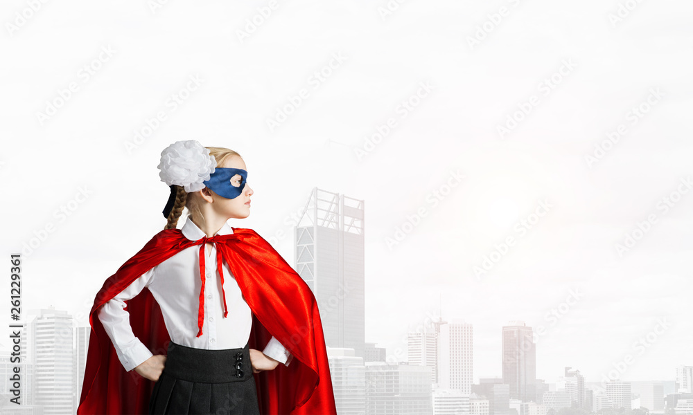 Girl power concept with cute kid guardian against cityscape background