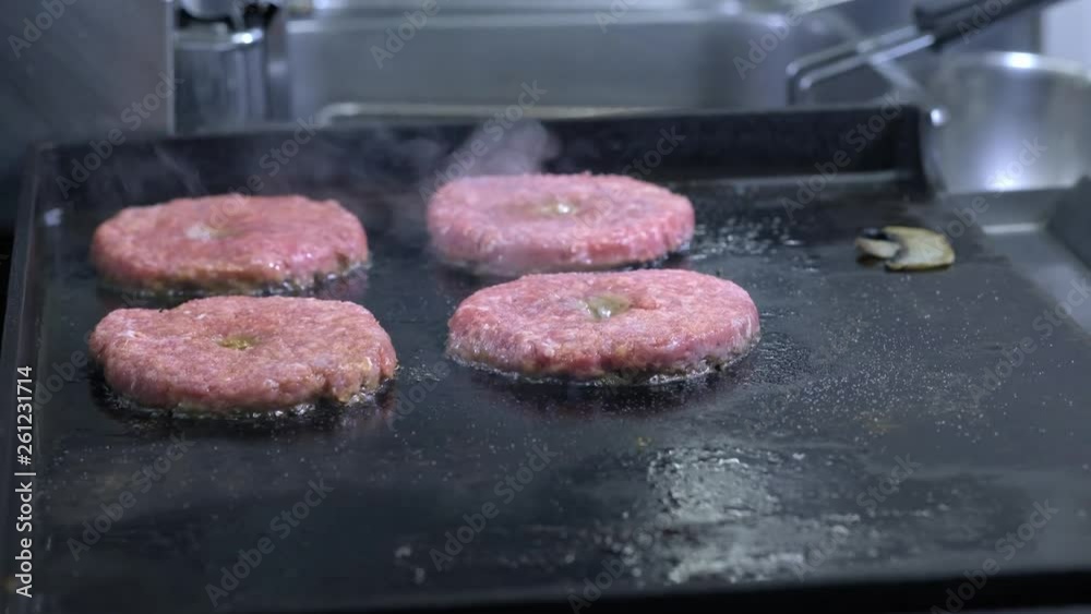 Cooking a hamburger, patty or steak. On a hot stove, a cook fries meat