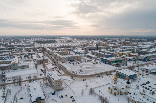 Church and city administration building in Yugorsk city. Aerial. Winter, snow, cloudy. Khanty Mansiysk Autonomous Okrug (HMAO), Russia.