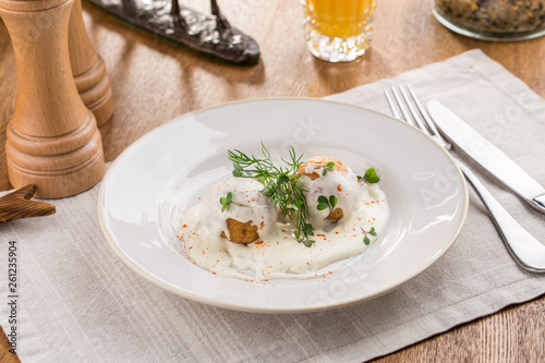 Meatball in white sauce bechamel and orange juice on wooden table