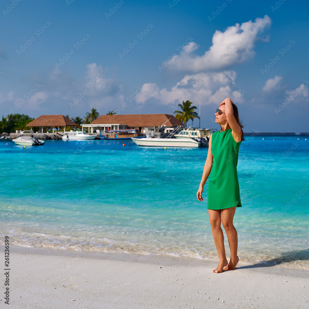 Woman in dress walking on tropical beach Woman in dress walking on tropical beach