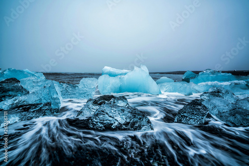 Icebergs on Diamond Beach in Iceland. Frozen ice on black sand beach known as Diamond Beach flows from Jokulsarlon beautiful Glacial Lagoon in Vatnajokull National Park, southeast Iceland, Europe. photo