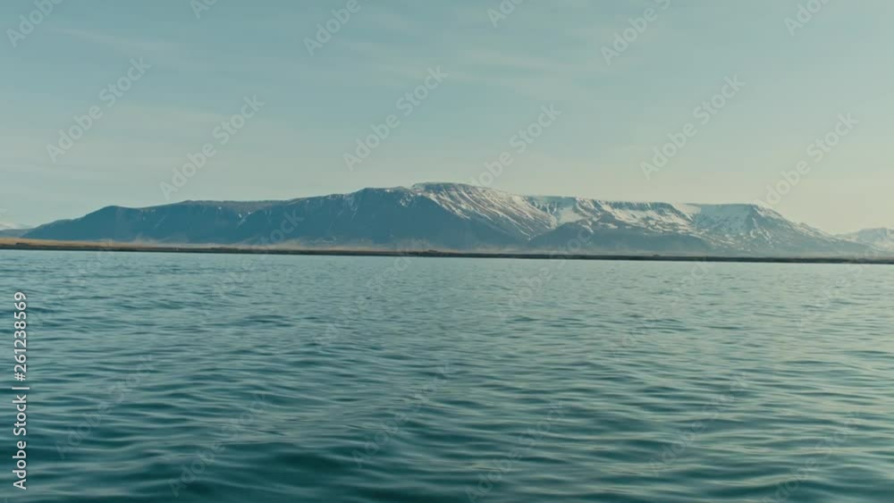 We see mountains passing on the horizon as we ride along on a boat. We see mountains passing on the horizon as we ride along on a boat.