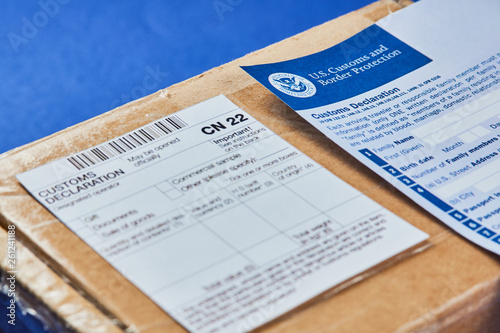 Customs Declaration Form lies on Parcel with Customs declaration form CN22 on a blue velvet background. Close-up.