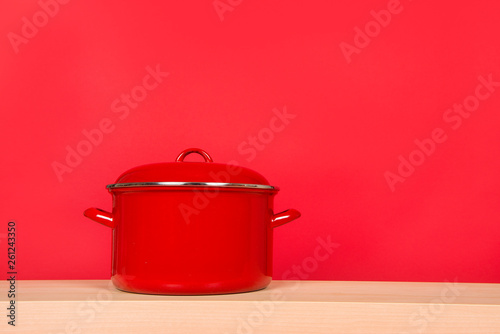 Large red cooking pan on a red background photo