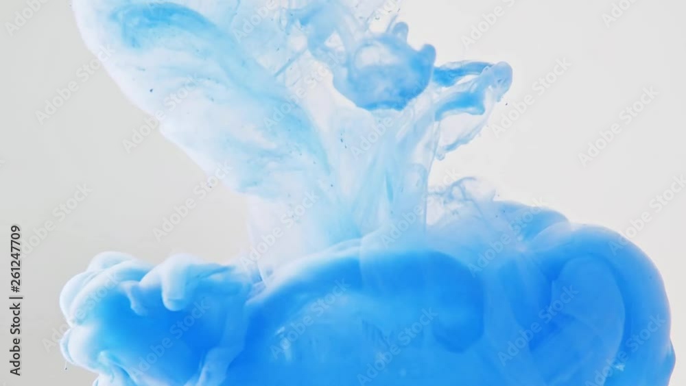 Blue ink dropped into water, close shot. Abstract background. Acrylic swirl in liquid. Drop of paint dissolving into water. Abstract pattern. Blue paint disapearing in liquid. Blurred background
