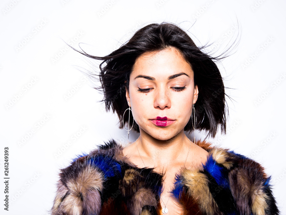 woman made up posing in a studio wearing a colorful coat woman made up posing in a studio wearing a colorful coat