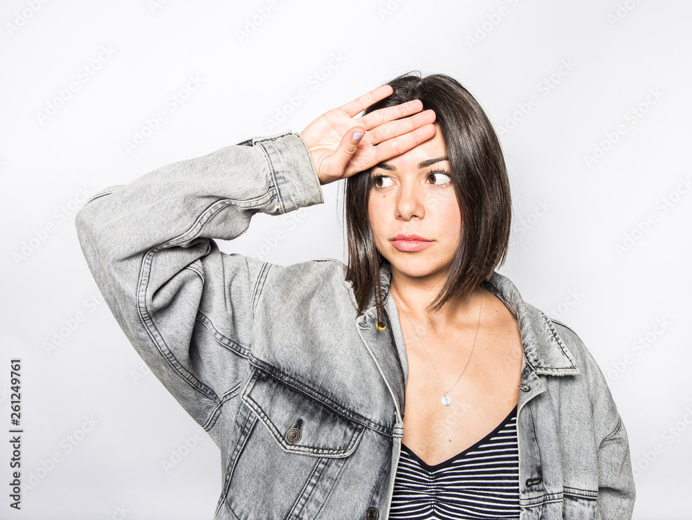 woman wearing a jean coat with her hand on his head making an expression with her face woman wearing a jean coat with her hand on his head making an expression with her face