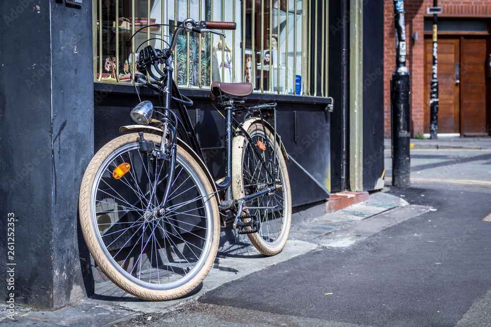 Bicycle leaning against a shop window